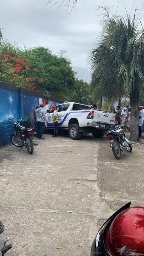 Una unidad de la Policía y varios curiosos en la escena donde un hombre atacó a tiros a varias personas en Higüey.