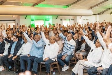 Miembros del Comité Nacional PRM levantan la mano para ratifica la Convención por Delegados de esa organización política