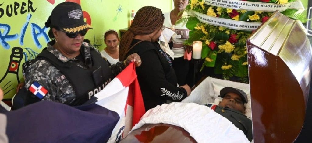 Hija del capitán Williams Méndez Ramírez, Wilkary Méndez, observa el cadáver de su progenitor cuando era velado en su casa en el sector Las Cañitas, de la capital, una comitiva de la Policía arropa con la Bandera Nacional el féretro.
Manolito Jiménez
