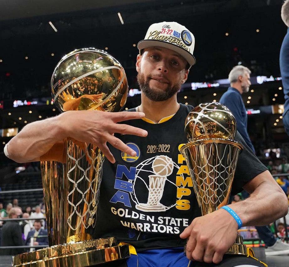 Steph Curry abrazo dos trofeos del campeonato de Golden State Warriors contra Boston.