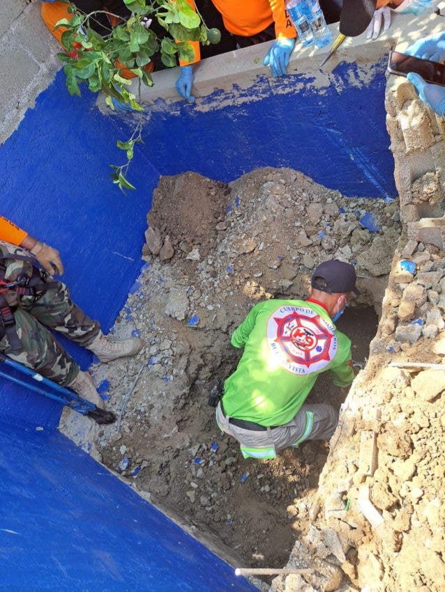 Un bombero cava en la construcción de una piscina donde fue encontrado el cadáver del empresario Fausto Reyes, en La Vega