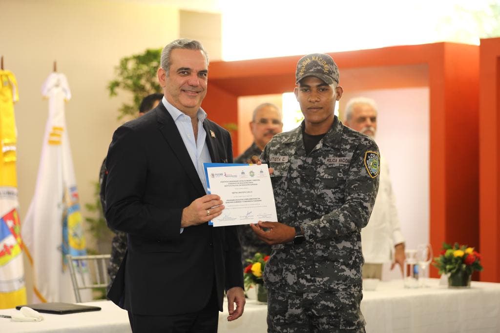 El presidente Luis Abinader entrega un certificado a uno de los agentes 757 de la Policía que se graduaron en derechos humanos y convivencia ciudadana