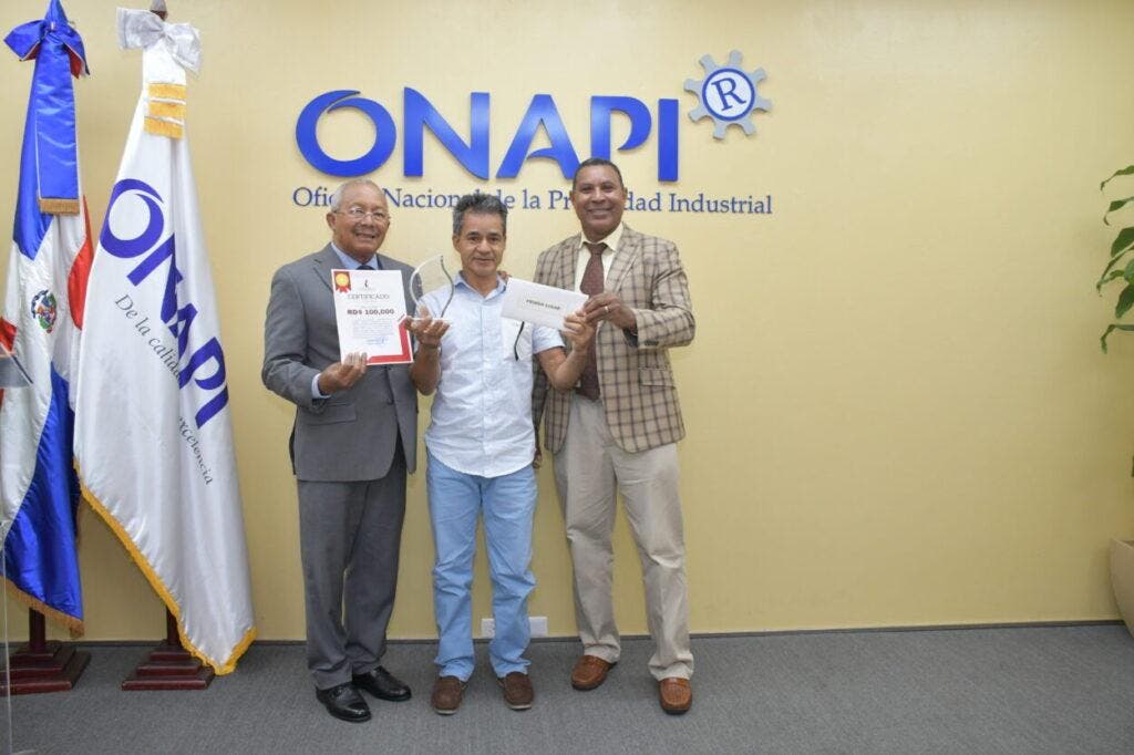 El director ONAPI, doctor Salvador Ramos, hace entrega a uno de los ganadores de al premiación en el Concurso Diseño Industrial