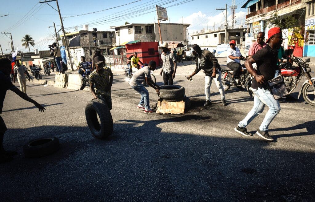 PUERTO PRÍNCIPE (HAITÍ).- Manifestantes protestan para exigir la renuncia del primer ministro Ariel Henry este jueves en Puerto Príncipe (Haití). Varias decenas de personas salieron este jueves a las calles de Puerto Príncipe para exigir la renuncia del primer ministro, Ariel Henry, que se encuentra en Puerto Rico tras un fallido intento de volver a su país el martes. EFE/ Johnson Sabin
