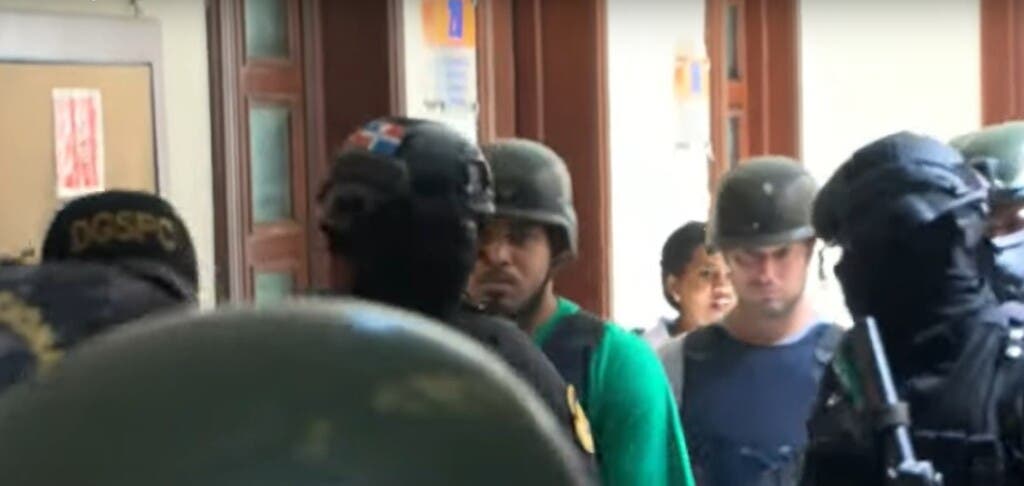 Jorge Luis Estrella Arias y Eddy Enmanuel Segura Arias imputados en el asalto al Banco Popular, cuando eran trasladado a la sala de audiencia para conocerle medida de coerción, la cual fue aplazada para este viernes.