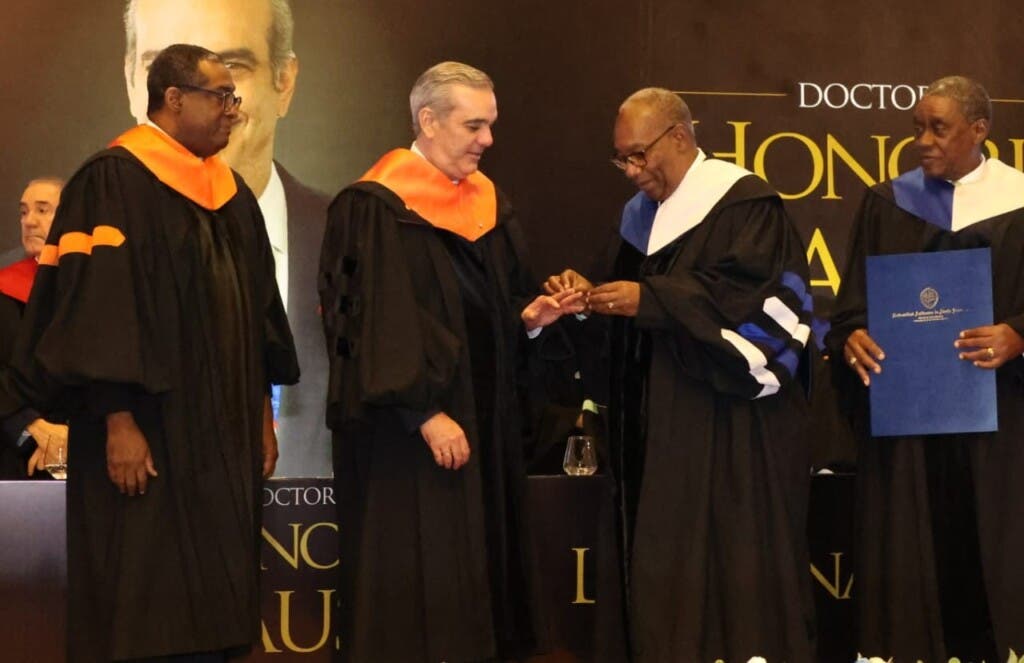 El rector de la UASD, Editrudis Beltrán, coloca el anillo del Doctor Honoris Causa al presidente Luis Abinader./Foto Guillermo Burgos