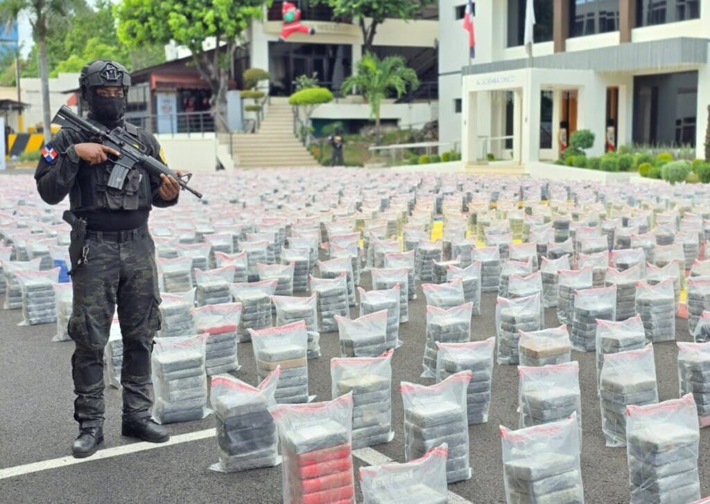 Un agente de la DNCD vigilia parte del cargamento de 9.5 toneladas de cocaína decomisado ayer en Caucedo
