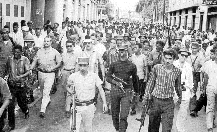 El coronel Caamaño Deñó acompañado de militares y civiles recorren la zona Colonial durante la Revolución del 24 de abril de 1965, un levantamiento militar exigió el retorno de Juan Bosch a la presidencia