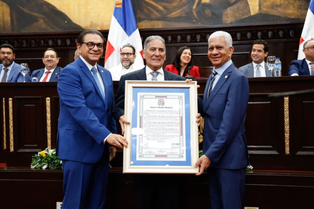 El cantautor Erasmo Alfonso Cáffaro Durán (Niní) al centro, recibiendo el reconocimiento de las manos del presidente del Senado, Ricardo de los Santos (d) y el senador Daniel Rivera (i). / Senado RD.