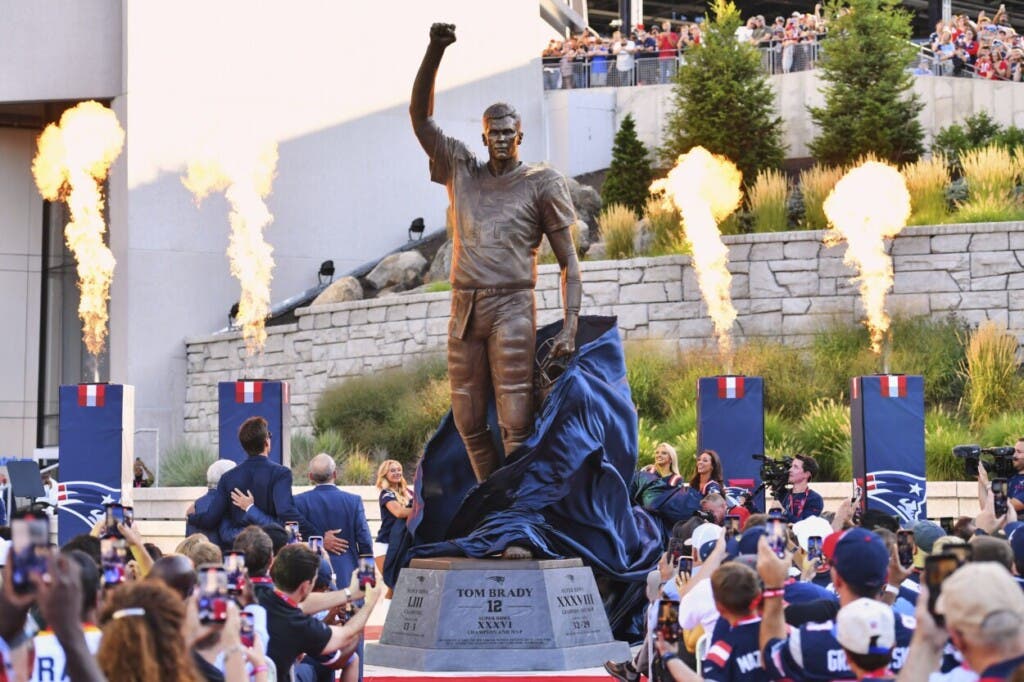 El exmariscal de campo de los New England Patriots, Tom Brady, habla tras la develación de su estatua de bronce en Patriot Place Plaza, el viernes 8 de agosto de 2025, en Foxborough, Massachusetts. (AP Foto/Charles Krupa).