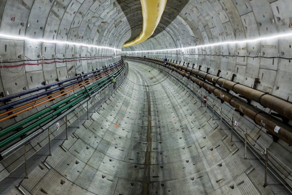 Un trabajador de la construcción avanza por una pasarela a nivel de las vías en el túnel del metro bajo el Canal de Panamá durante una visita de prensa, en Arraiján, al oeste de la Ciudad de Panamá, el martes 23 de septiembre de 2025. (Foto AP/Matias Delacroix)