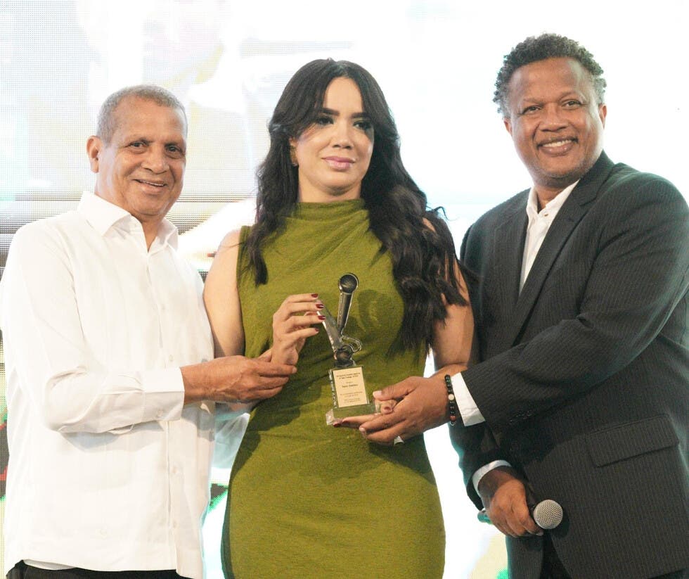 Sussy Jiménez recibe el premio Marcia Facundo como mejor cronista femenina. La entregan la hicieron Leo Corporán y Aquiles Correa.