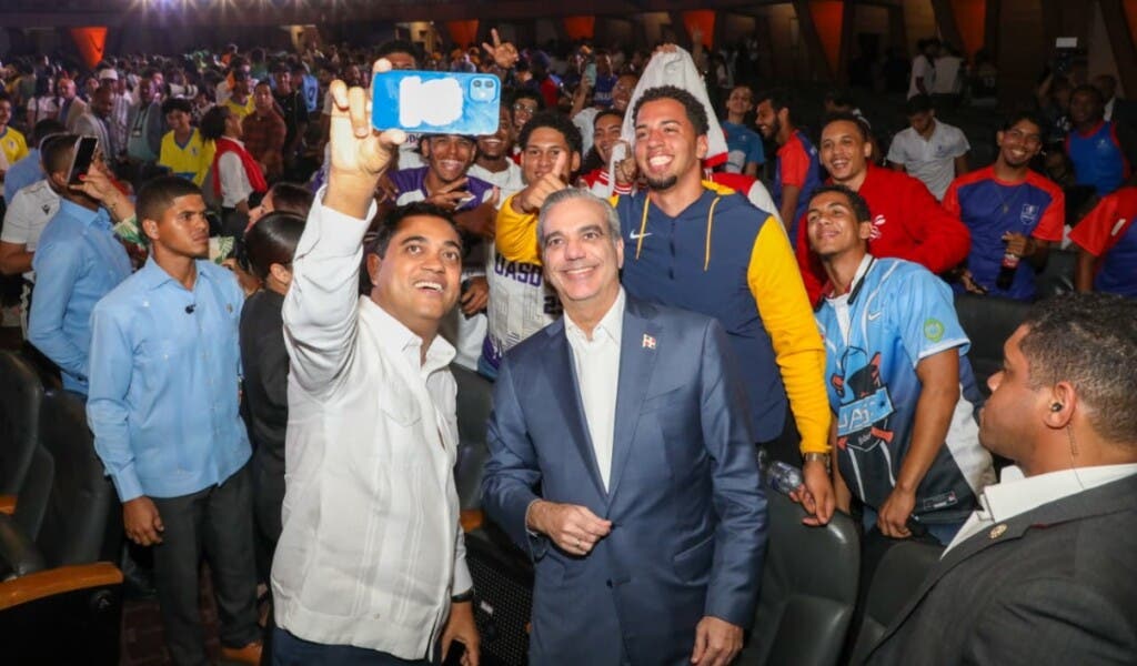 El ministro Kelvin Cruz se hace una selfie con el presidente Abinader en el Aula Magna.