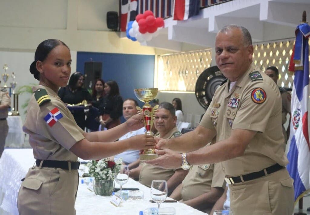 El teniente general Carlos Antonio Fernández Onofre, ministro de Defensa, premia a Esther Mezquita del ERD, como la atleta más destacada de los Juegos de Cadetes.