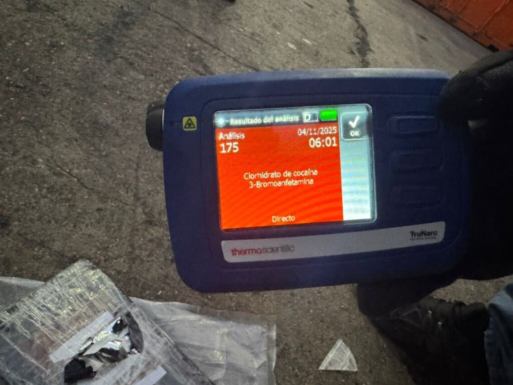 Un miembro de la DNCD verifica si los paquetes incautados son de cocaína