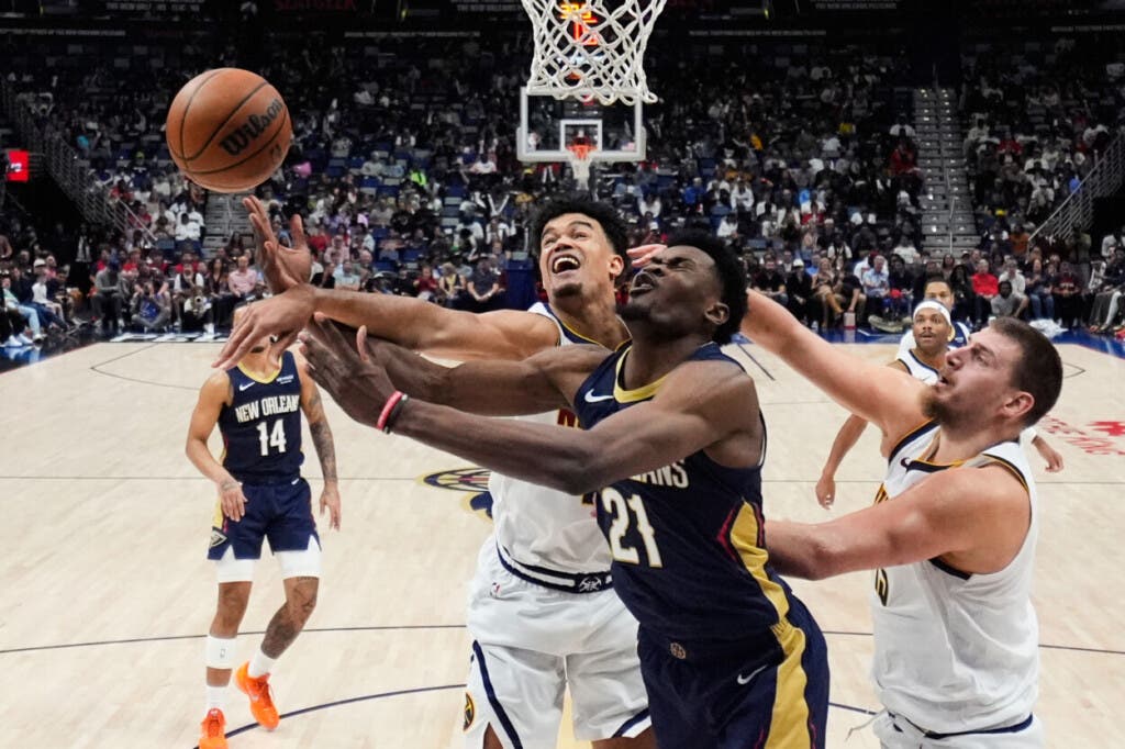 El pívot de los New Orleans Pelicans, Yves Missi (21), lucha bajo el aro con el alero de los Denver Nuggets, Spencer Jones (izquierda), y el pívot Nikola Jokic durante la segunda mitad de un partido de la NBA, el miércoles 19 de noviembre de 2025, en Nueva Orleans. (Foto AP/Gerald Herbert)