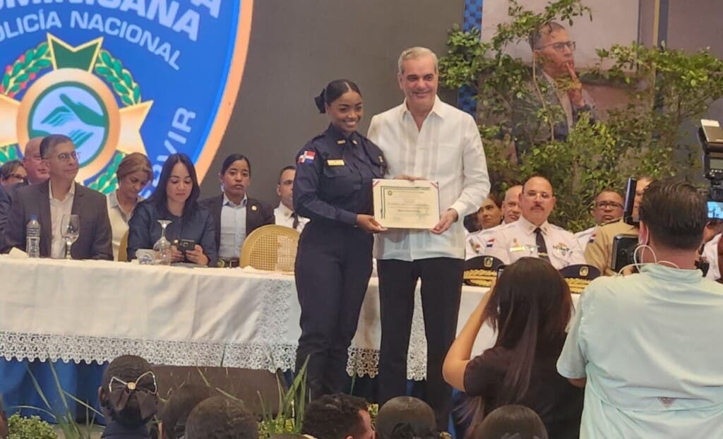 El presidente Luis Abinader entrega el certificado a una policía que se graduadó en la tercera promoción de los nuevos agentes de la Policía Nacional bajo la nueva malla curricular educativa.