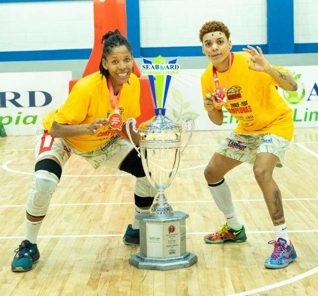 Las jugadoras Sugey Monsac y Jennifer Jiménez, de las Águilas de Guachupita, junto a la Copa Seaboard que le ganaron a San Carlos. / Fuente externa.