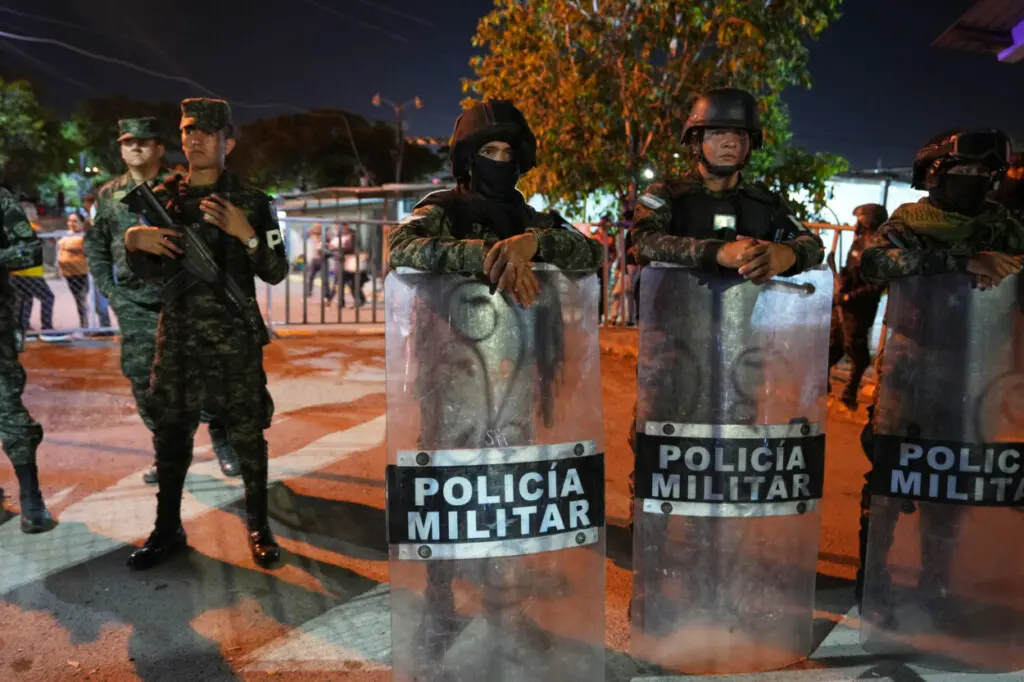 La policía militar monta guardia mientras simpatizantes del partido LIBRE protestan por los resultados de las elecciones generales en Tegucigalpa, Honduras, el miércoles 10 de diciembre de 2025. (Foto AP/Moisés Castillo)