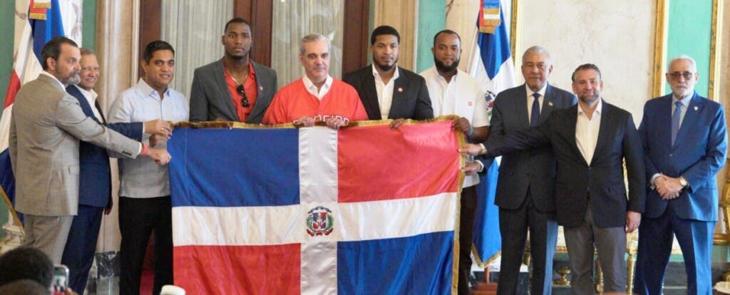 El presidente Luis Abinader  entrega la bandera dominicana en el Palacio Nacional al capitán del Escogido, Jimmy Paredes, Junior Lake y Sócrates Brito. Estuvo acompañado, desde la izquierda, por José Miguel Bonetti Du-Breil, Leonardo Aguilera, Kelvin Cruz, Andrés Bautista, Eduardo Najri y Vitelio Mejía. La delegación  salió al mediodía de hoy.