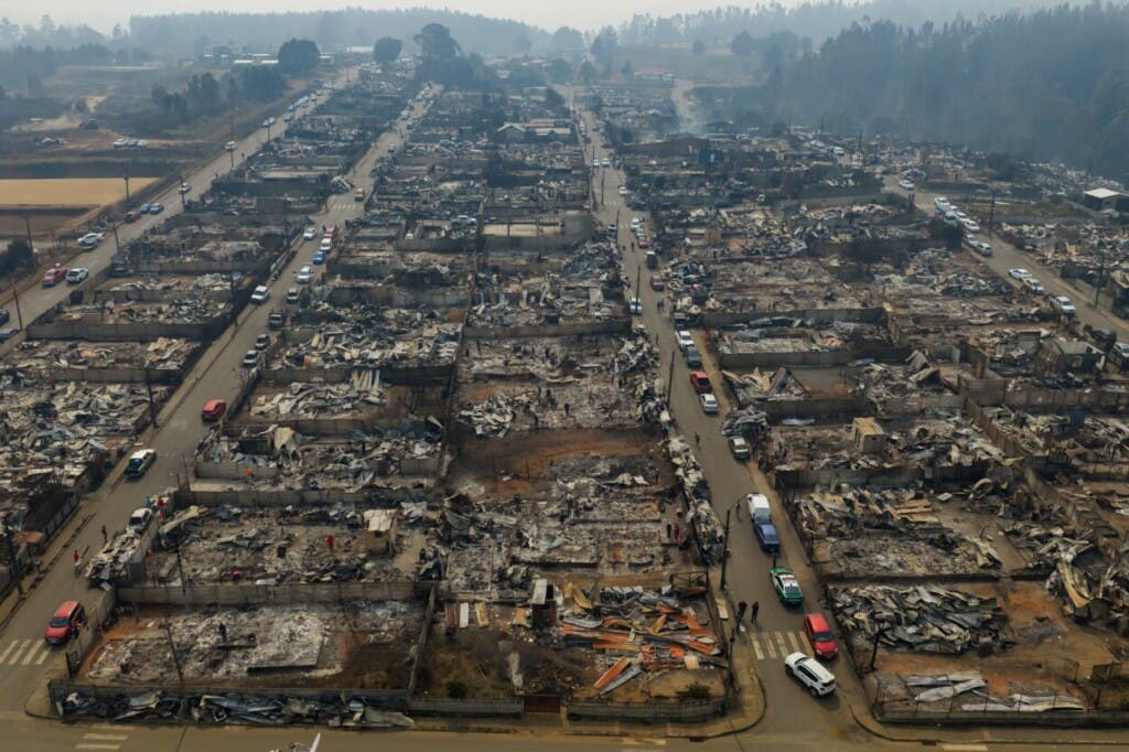 Áreas residenciales quemadas por incendios forestales se extienden por Tomé, Chile, el lunes 19 de enero de 2026. (AP Foto/Javier Torres)