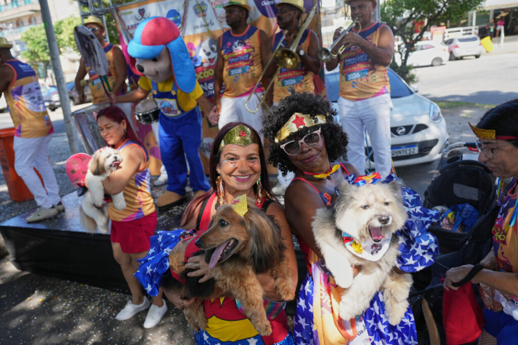 Propietarias y sus mascotas posan para una foto en un desfile canino en el Carnaval, el sábado 14 de febrero de 2026, en Río de Janeiro. (AP Foto/Silvia Izquierdo)
