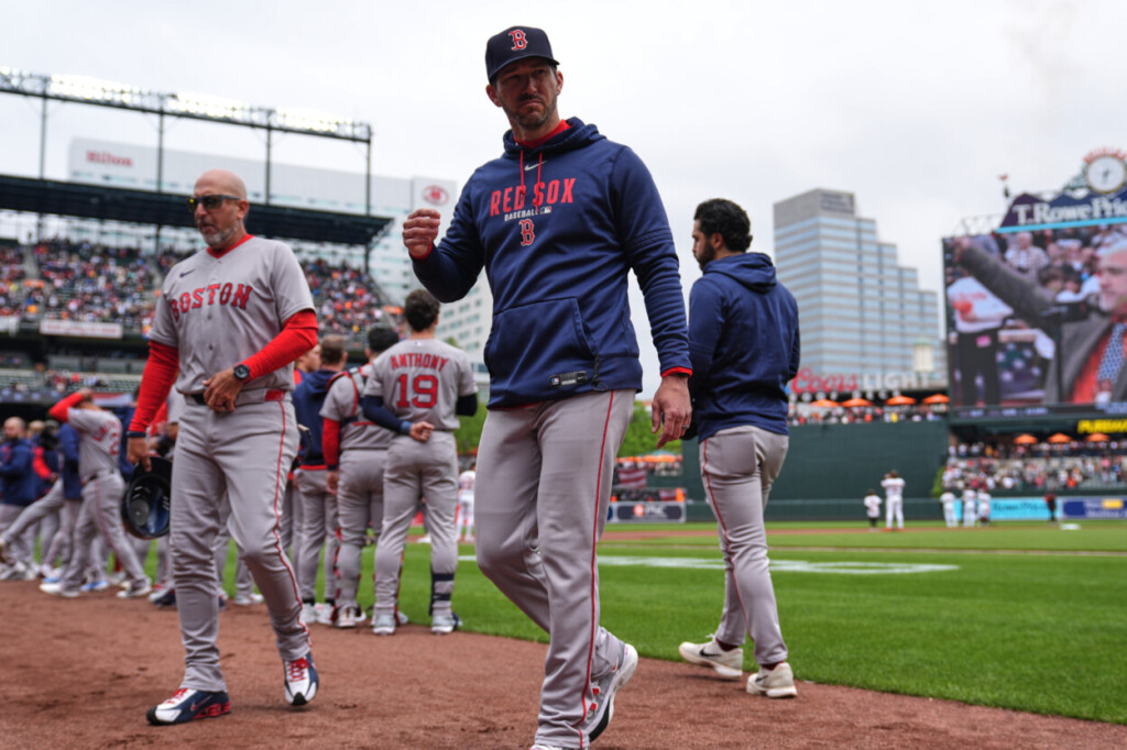 El mánager interino de los Medias Rojas de Boston, Chad Tracy, regresa al banquillo tras ponerse de pie para el himno nacional antes de un partido de béisbol contra los Baltimore Orioles, el domingo 26 de abril de 2026, en Baltimore. (Foto AP/Stephanie Scarbrough)