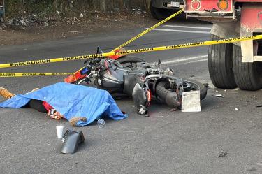 El joven motorista murió aplastado por un camión mientras intentaba cruzar la peligrosa vía junto a un acompañante.