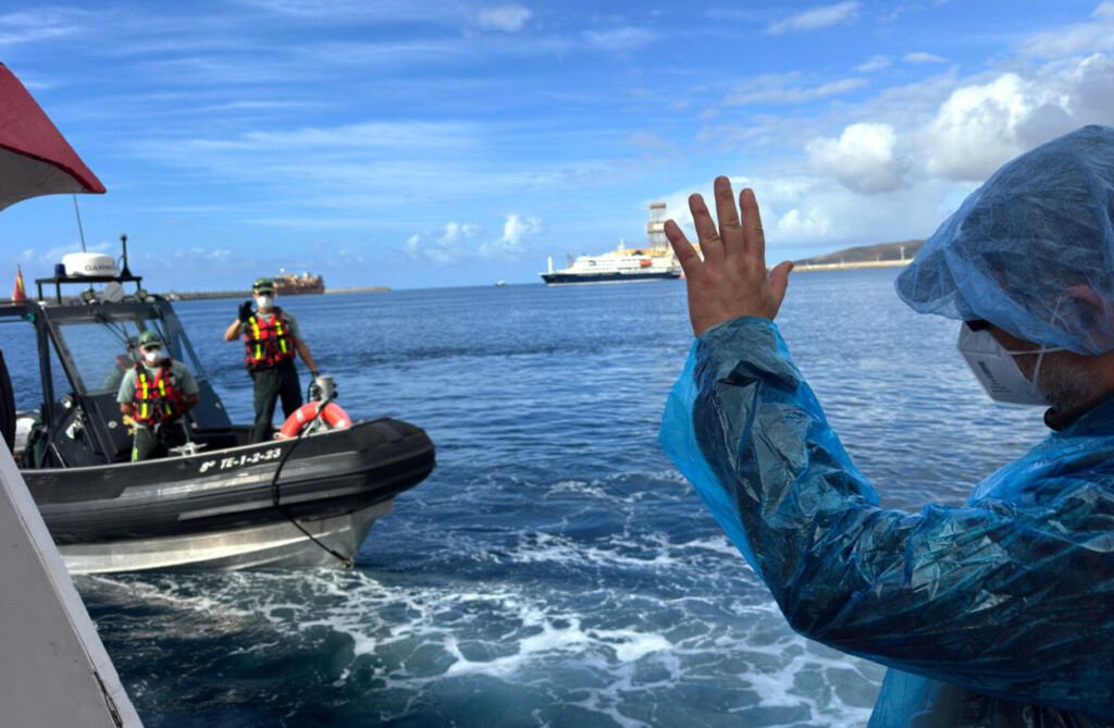 Un pasajero saluda a agentes de la Guardia Civil mientras desembarcan del crucero MV Hondius, afectado por un brote de hantavirus, en el puerto de Granadilla, en la isla canaria de Tenerife, España el domingo 10 de mayo de 2026. (AP Foto)
