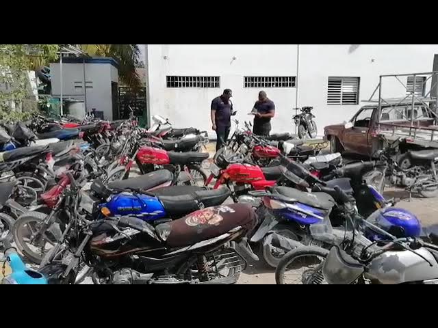 Miembros de la
Policía Nacional junto a las motores ocupadas y los tres jóvenes arrestados durante el operativo contra una presunta red dedicada al tráfico ilegal de motores hacia la frontera de
Elías Piña .
